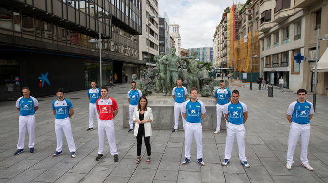 Diez de los participantes en el torneo Masters e Isabel Moreno, directora territorial de CaixaBank, posan delante del monumento al Encierro.