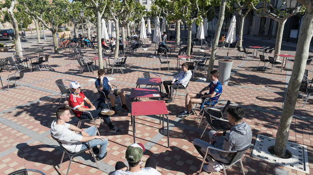 Imagen de un grupo de jóvenes sentados en una terraza respetando la distancia de seguridad en Los Paseos de Cintruénigo.