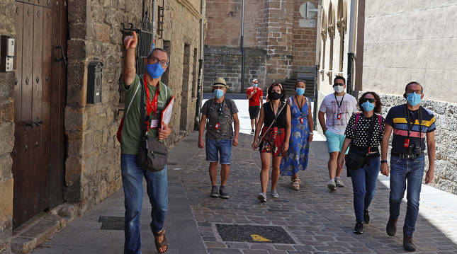 El guía, Mikel Ollo, explica a tres parejas de turistas las curiosidades de la ciudad dentro de la visita Pamplona al Completo.