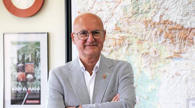 Foto del consejero Bernardo Ciriza posa en su despacho del departamento, delante de un mapa de Navarra en relieve.