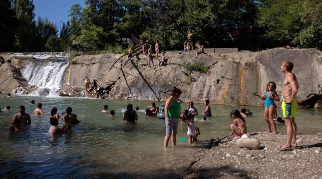 Numerosas personas se han refrescado en los últimos días en los ríos navarros, como las de la imagen en Huarte.