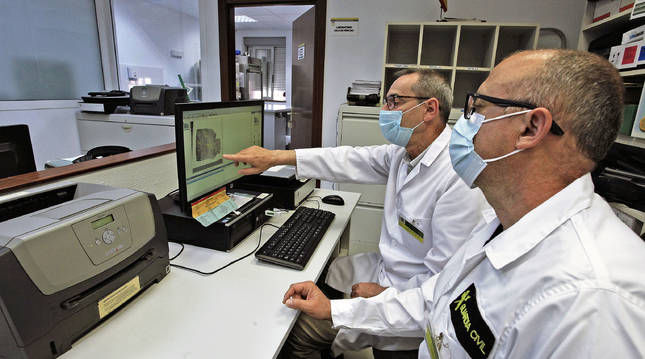 Dos agentes del laboratorio de criminalística de la Guardia Civil en Navarra analizan una huella en el SAID.