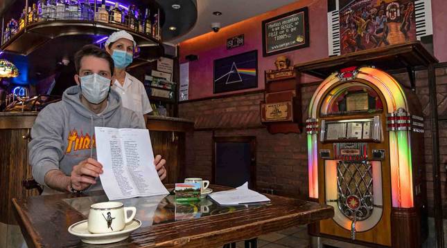 Jon Gorria junto a su madre María Jesús Plaza en el bar con la carta, las tazas y el imán.