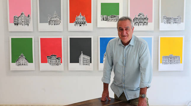 Iñaki Pardos posa junto a algunas de sus obras de fondos coloristas sobre edificios emblemáticos y reconocibles de Pamplona.