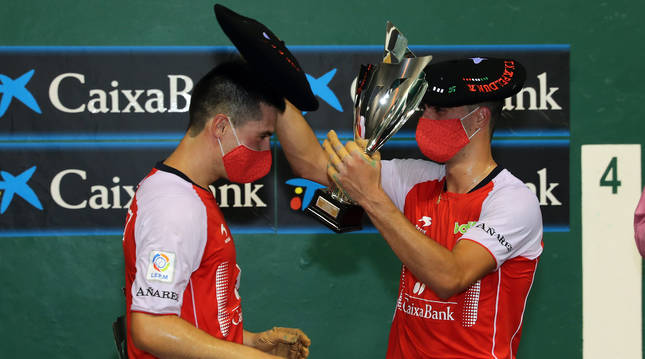 Josu Eskiroz, a la izquierda, recibe la txapela de campeón de Parejas de Promoción por parte de Asier Agirre.