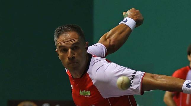 Aimar Olaizola golpea a una pelota durante un partido del Masters Caixabank, con José Javier Zabaleta al fondo.