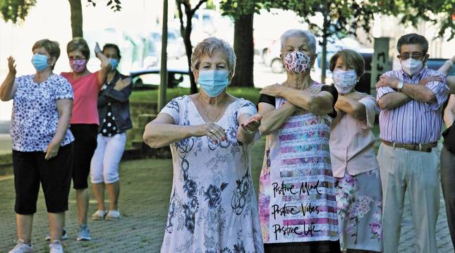 Foto de un grupo de mayores de la Txantrea se juntan todos los martes para la actividad de baile al aire libre, con las monitoras del centro Convive Santesteban, en la Txantrea.