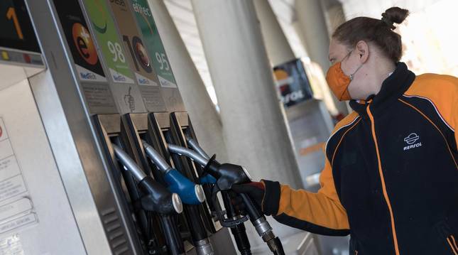 Foto de una empleada de la gasolinera San Rafael de Tudela se dispone a surtir de carburante a un vehículo.