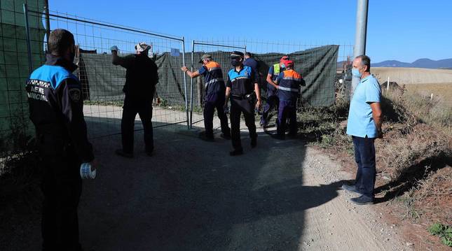 foto de A la derecha, Tomás Labiano, propietario del terreno, observa cómo agentes y empleados municipales proceden al precinto de la instalación en Paternáin.
