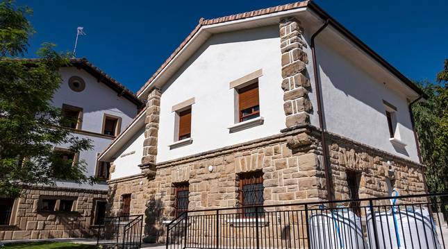 Foto del consultorio médico, en primer plano y, al fondo, la casa consistorial de Améscoa Baja..