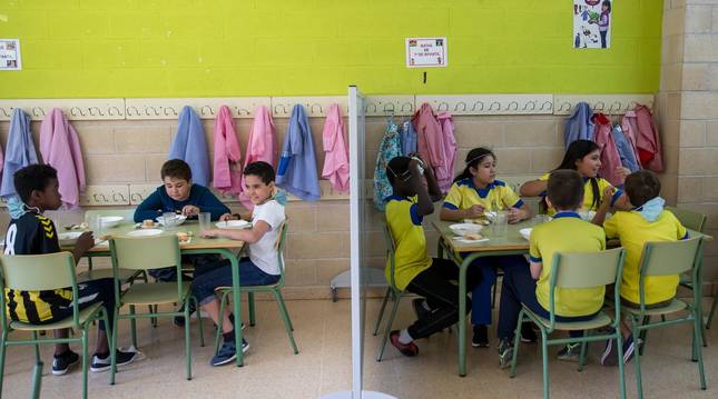 Foto de los alumnos comiendo con compañeros de su misma clase, grupo de convivencia estable, y se separan de los demás con mamparas para evitar el contagio del covid.
