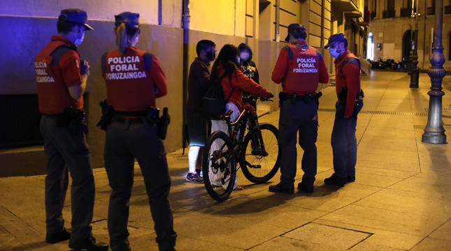 Agentes de Policía Foral comprueban el uso de mascarilla por unos jóvenes el sábado por la noche en Pamplona.