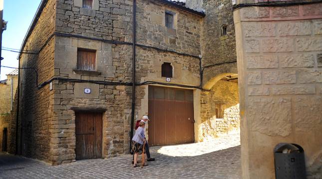Foto de una pareja caminando entre las empedradas calles de Ujué. Este atípico verano ha dejado a sus habitantes sin fiestas en septiembre.