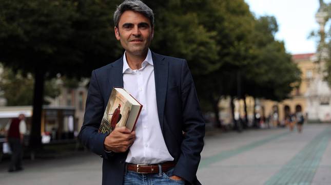 Foto de Juan Torres Zalba, posando en el Paseo Sarasate con un ejemplar de El primer senador de Roma, cuya trama está ambientada en el siglo II antes de Cristo.