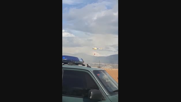 Un helicóptero recoge agua para sofocar el incendio de una escombrera en Lumbier