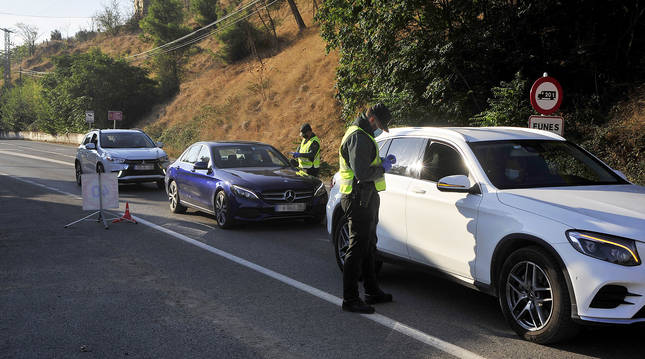 Agentes de Guardia Civil comprueban los justificantes de vehículos que salen de Funes.