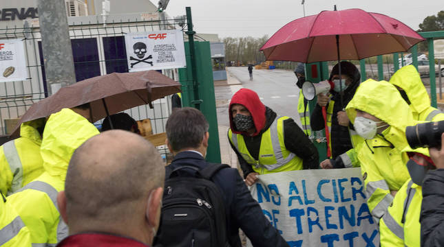 El abogado de la empresa CAF tuvo problemas para entrar a la reunión en la fábrica de Castejón. Lo intentó una primera vez, pero se encontró con un grupo de trabajadores que no lo permitió. Luego llegó la Guardia Civil, se abrió un pasillo para que pudiera pasar y logró acceder al interior, aunque tuvo que escuchar los gritos de los trabajadores en su contra, como se aprecia en la imagen.
