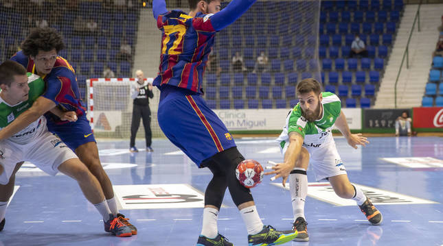 Foto de Juan del Arco (Helvetia Anaitasuna), buscando un complicado pase a Antonio Bazán en el pivote entre la defensa del Barcelona.