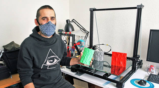 Martin Etxauri en el taller donde trabaja en su casa de Barañain. Junto a él, la impresora en 3D y una pieza de corteza de árbol en plástico.