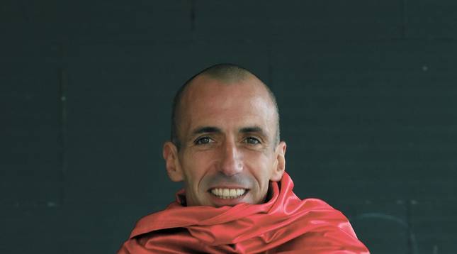 Foto de Patxi Puñal, enfundado en una bandera de Osasuna gigante, en su localidad natal, Huarte.