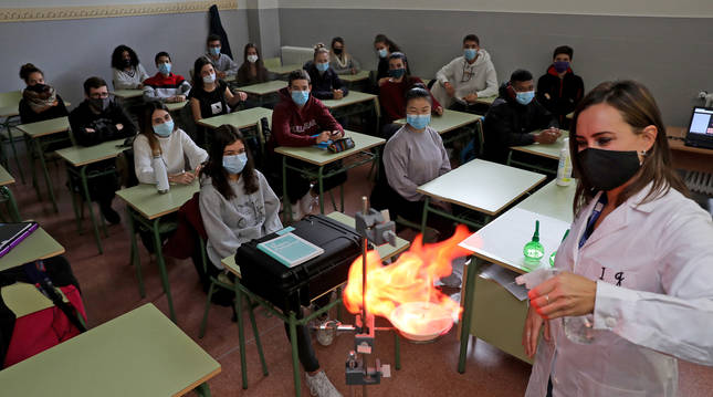 Foto de alumnos y la profesora de Química del IES Iturrama, Izaskun Jorajuria Elizondo, en el experimento 'La llama de colores'.
