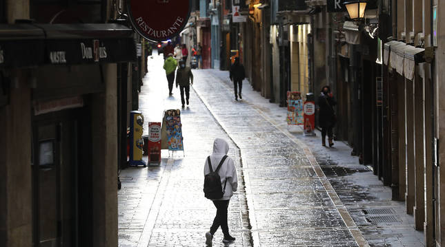 Gente caminando por la calle Comedias de Pamplona este lunes, primer día del toque de queda.