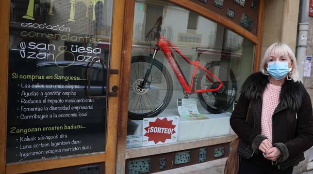 Marta Villanueva Ruiz, presidenta de los comerciantes de Sangüesa, junto a la bici eléctrica que sortearán.