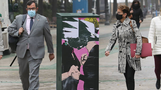 El portavoz Javier Remírez y la presidenta María Chivite pasan junto al destrozado cartel de El beso, camino del Parlamento, una obra del artista callejero LKN, que pintó a Chivite y Bakartxo Ruiz (Bildu) besándose, por el futuro pacto presupuestario.
