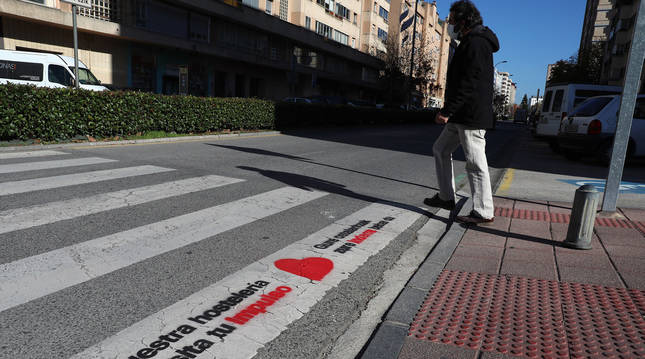 Foto de uno de los pasos de cebra de Barañáin (Navarra) con el eslogan de la campaña de apoyo al comercio local sobrepintado.