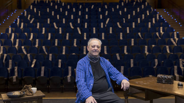 Fernando Eugui sobre el escenario de la casa de cultura de Villava con parte del atrezzo de la obra. Al fondo, la sala de butacas, muchas de ellas precintadas.