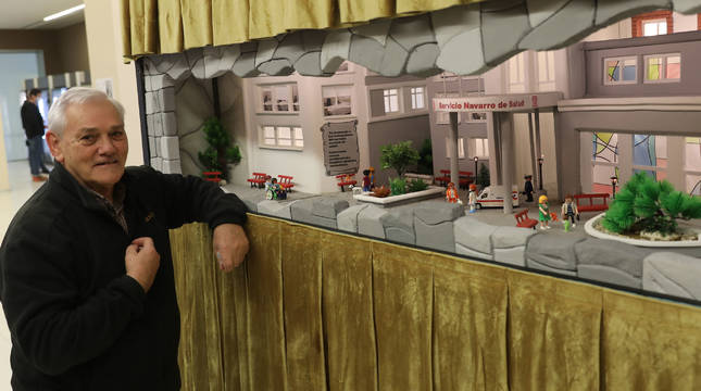 Mateo Viguria posa junto al belén que recrea el edificio principal del Complejo Hospitalario.