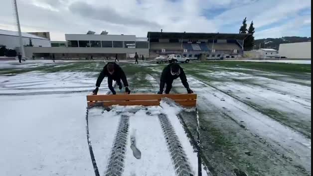 El entrenador del Izarra, Pablo Álvarez, ayuda a quitar la nieve de Merkatondoa