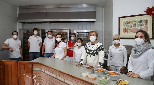 Conchita Osácar, en el centro, junto a los empleados de Asados labea, en la calle Esquíroz.