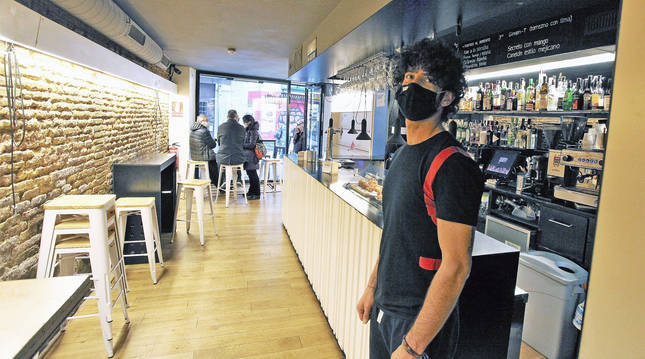 Foto de Adrián Romero, camarero del bar Qwerty, en Mercaderes. Desde el sábado intentarán sobrevivir con cuatro barriles y comida para llevar.