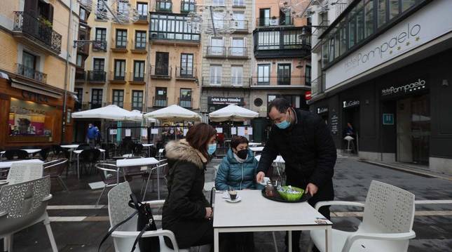 Varios clientes son atendidos en una terraza de la plaza del Ayuntamiento en Pamplona