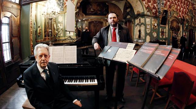 Aurelio Sagaseta, maestro de la Capilla de Música de la Catedral de Pamplona, sentado frente a la partitura del Réquiem de Mozart que se conserva en el Archivo de Música de la Catedral. De pie, Rafael Zafra, investigador de la Universidad de Navarra, en la sacristía rococó de la Catedral.