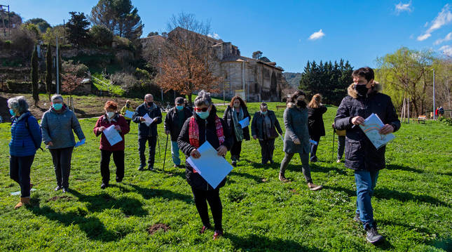 Vecinos que asistieron a la asamblea convocada junto al Santo Sepulcro caminan por la pradera.