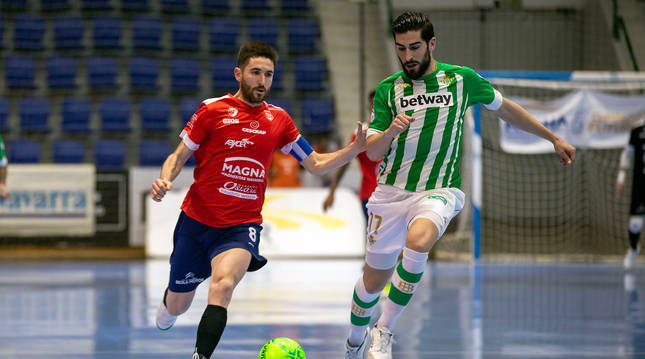 El capitán de Osasuna Magna, Roberto Martil, trata de llegar al balón ante la defensa de Buendía, bético que logró el empate a 2.