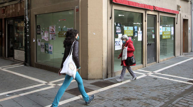 Dos mujeres pasan junto a uno de los locales comerciales que permanecen vacíos en el Casco Antiguo.