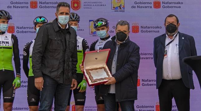 Manolo Azcona, flanqueado por Miguel Induráin y Miguel Ángel García Mitxelena, con su equipo Kern Pharma al fondo, ayer en la salida de Estella.