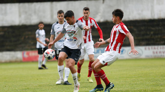 Gualda, del Tudelano, disputa un balón con Beñat Prados, del Bilbao Athletic, en el partido disputado en el Ciudad de Tudela.
