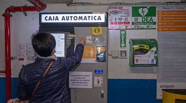 Una usuaria abona su pago en metálico al ir a recoger su vehículo del parking subterráneo de Estella.