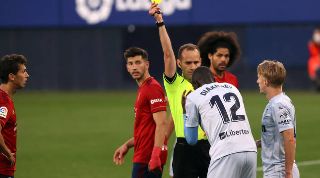 El andaluz Mario Melero López enseña una amarilla a Diakhaby durante el choqyue de la Jornada 31 en El Sadar.