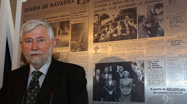 Foto de Florencio Domínguez ante uno de los paneles que muestran portadas de Diario de Navarra con atentados de ETA en la exposición del Palacio del Condestable.