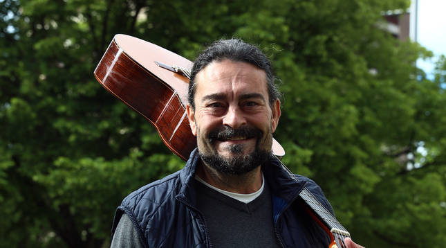 Chicho Sanz Nicuesa cerca de su lugar de trabajo, en Pamplona, con la guitarra al hombro.