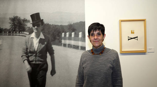 Glòria Bordons, comisaria de la exposición, junto a una fotografía de Joan Brossa.