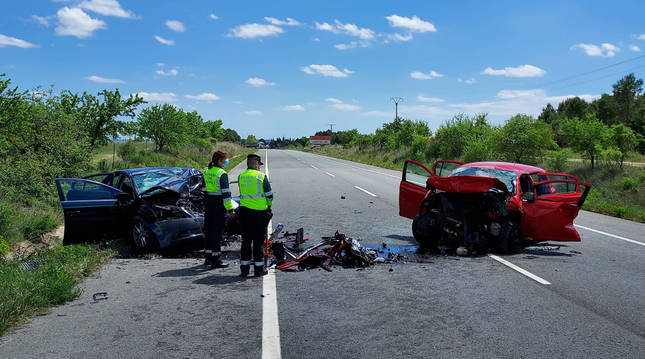 Dos agentes de la Guardia Civil junto a los vehículos implicados en el accidente.