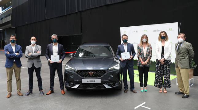 De izquierda a derecha, Carlos de Luis (director de Comunicación de Cupra España), Iñigo Alzueta (coordinador de Motor de Diario de Navarra), Miguel Ayerra (gerente de Iruña Motor), Víctor Sarasola (director comercial de Cupra España), Alicia Nicolás (directora comercial de Diario de Navarra), Carmen Cruz (directora de desarrollo de red de Cupra España) y Luis Colina, (presidente del Grupo La Información), junto al coche ganador, el Cupra Formentor, en el marco de la Feria 'Ecomovers'.