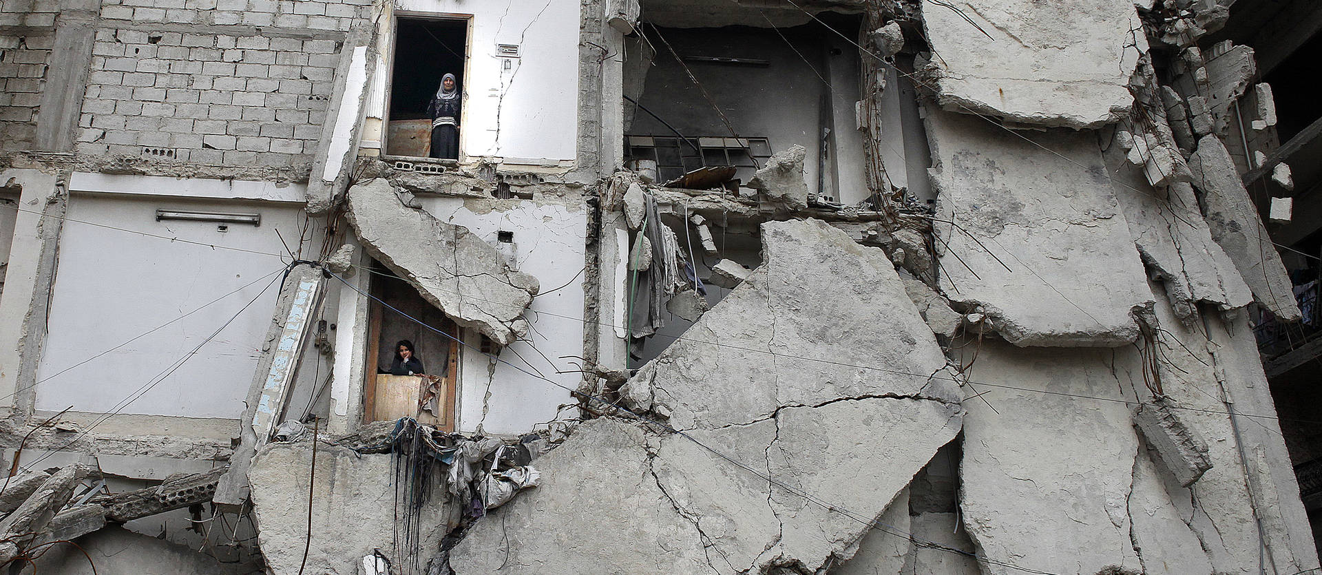 Foto de 13 de febrero de 2020. Dos vecinas se asoman por las puertas de sus casas en el edificio en el que viven en Ghouta, Damasco